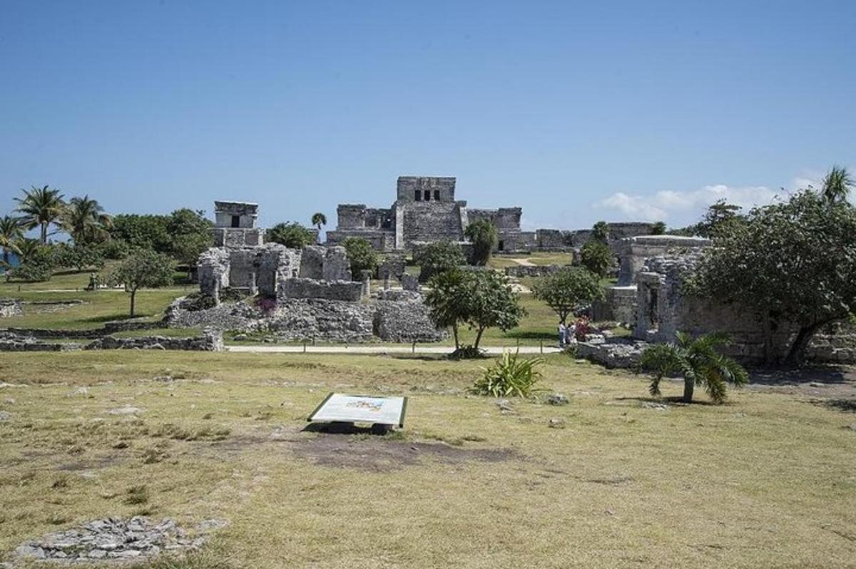 Un edificio en un campo con un cartel delante.