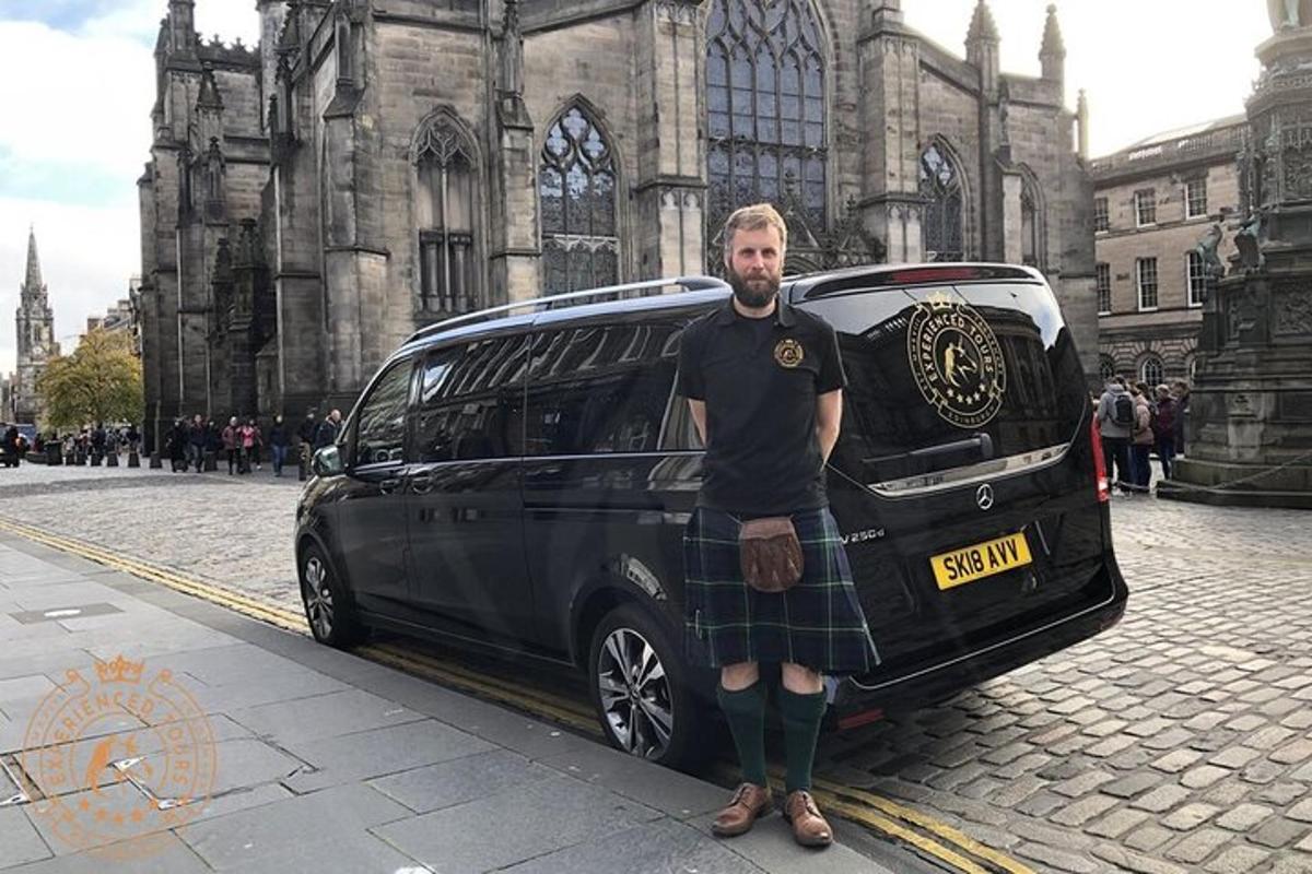 en mann i kilt som står ved siden av en varebil