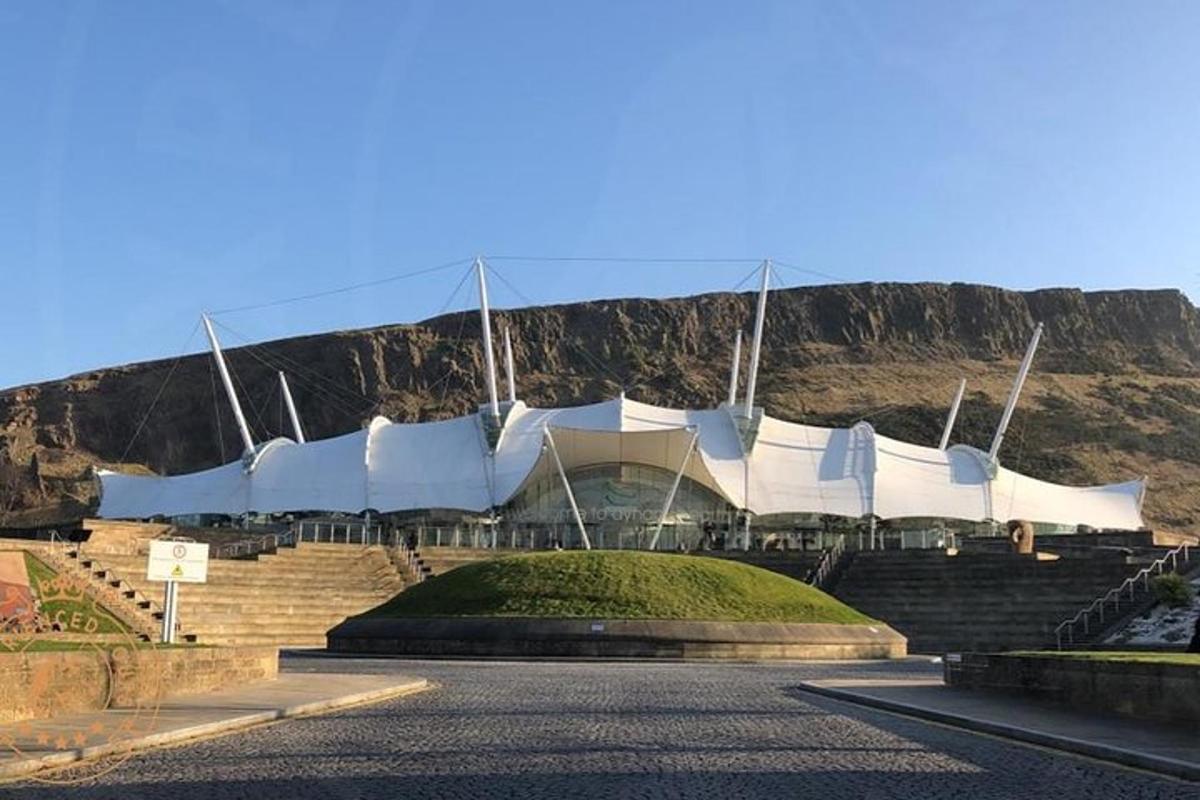 un grande edificio bianco con una montagna sullo sfondo