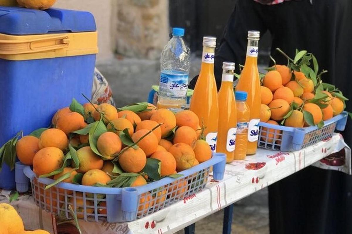 Δύο καλάθια με πορτοκάλια σε ένα τραπέζι με μπουκάλια αναψυκτικών