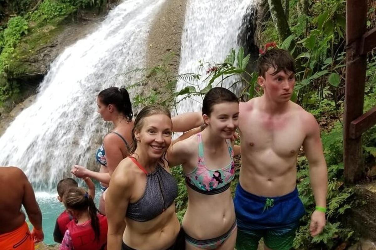 a group of people standing in front of a waterfall