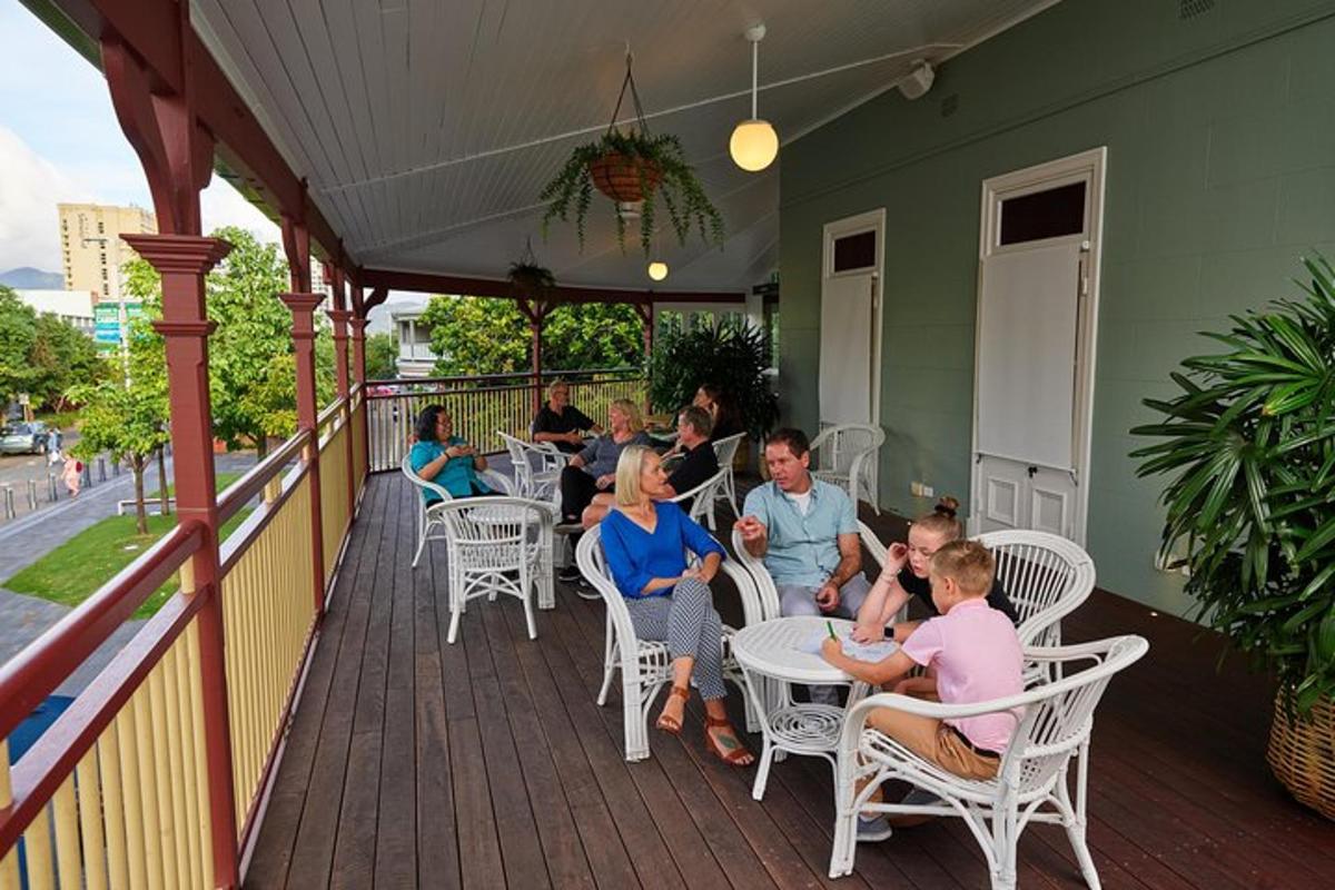 a group of people sitting at tables on a porch