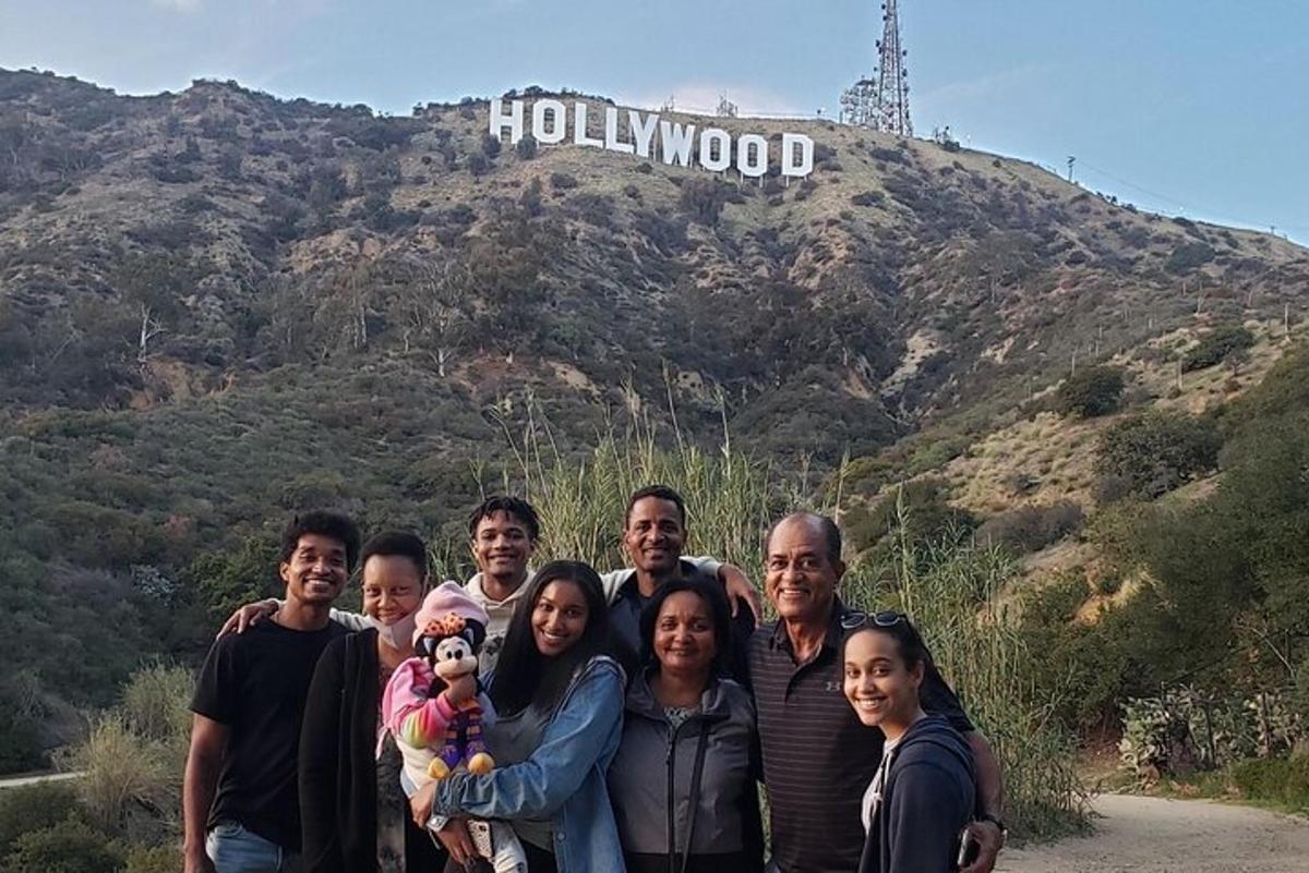 Skupina lidí stojících před hollywoodským nápisem