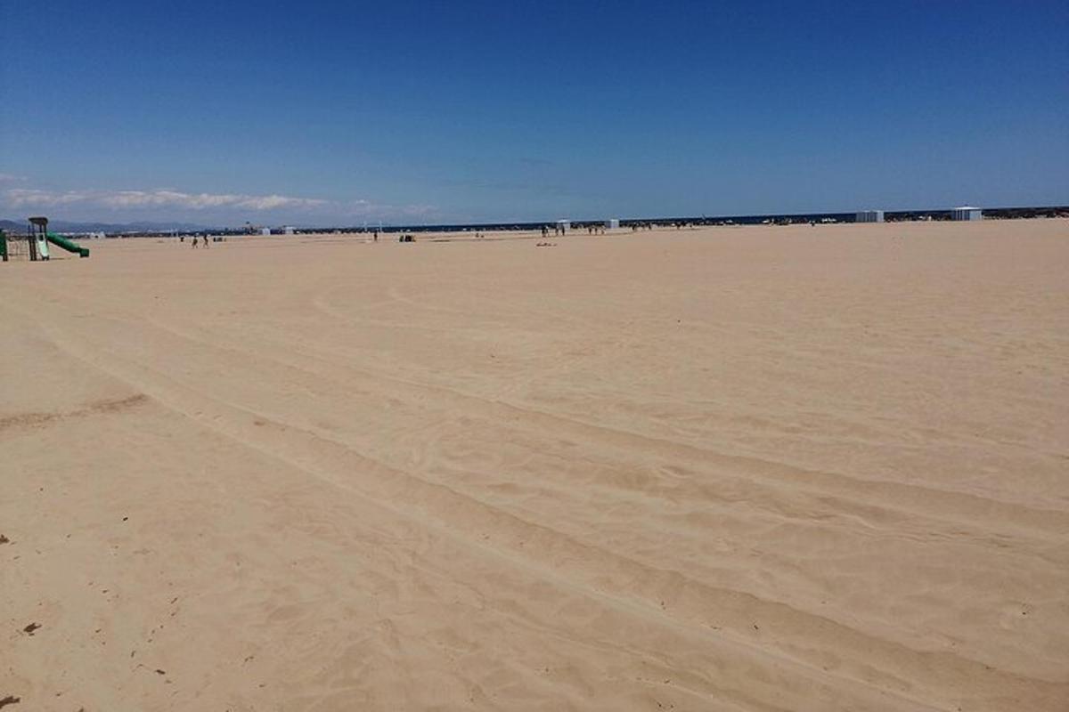 ein leerer Strand mit Menschen, die auf dem Sand spazieren