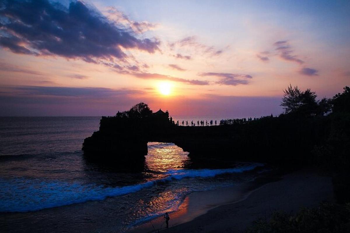 a sunset on a beach with the sun setting over the ocean