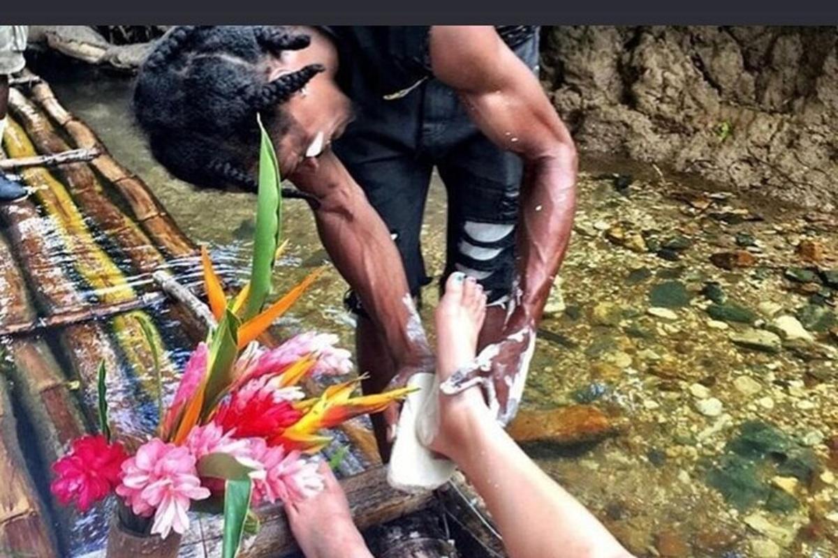 una persona che prende un fiore da un orso nell'acqua