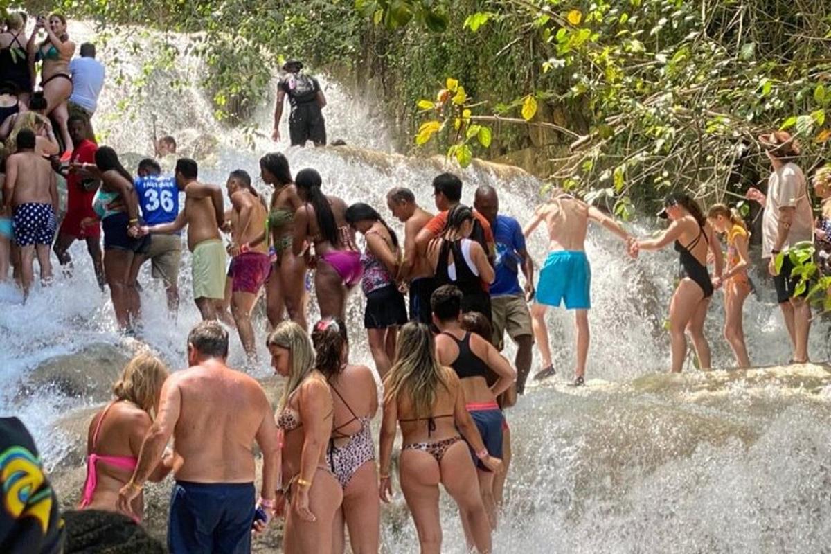 um grupo de pessoas em trajes de banho em uma cachoeira