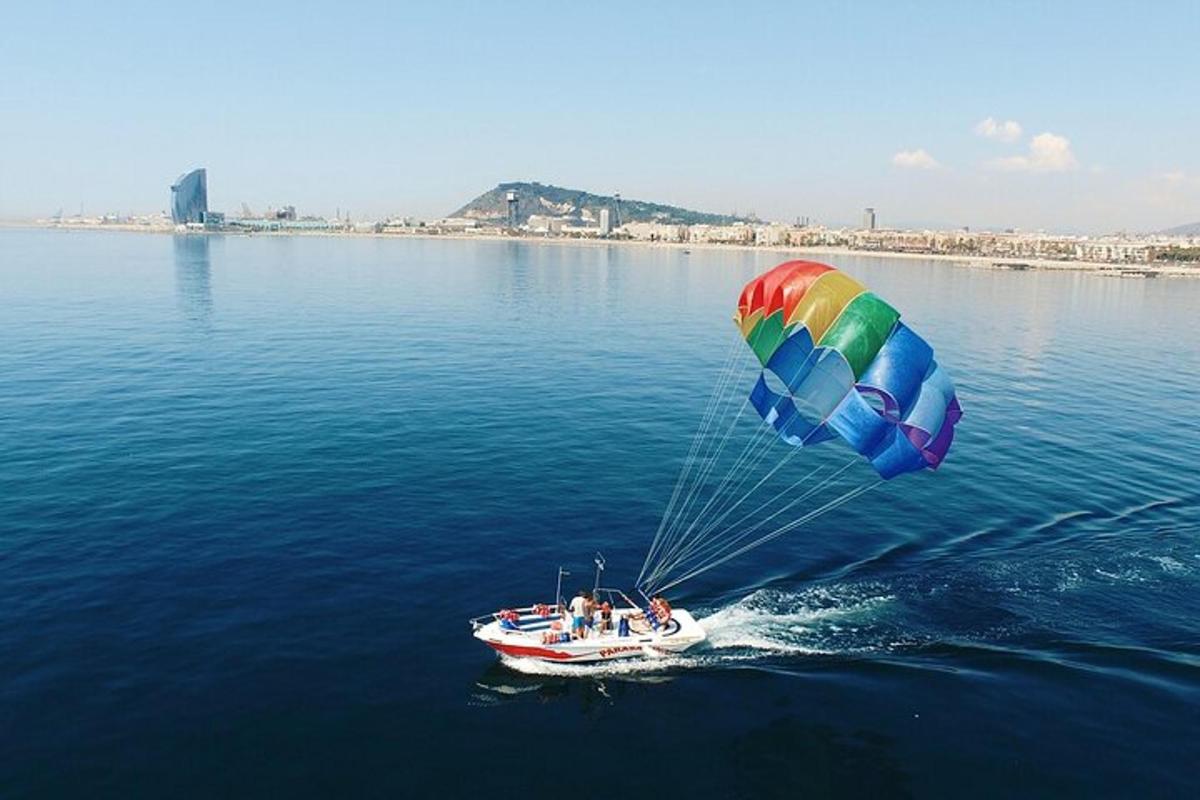 a group of people on a boat in the water with a parachute