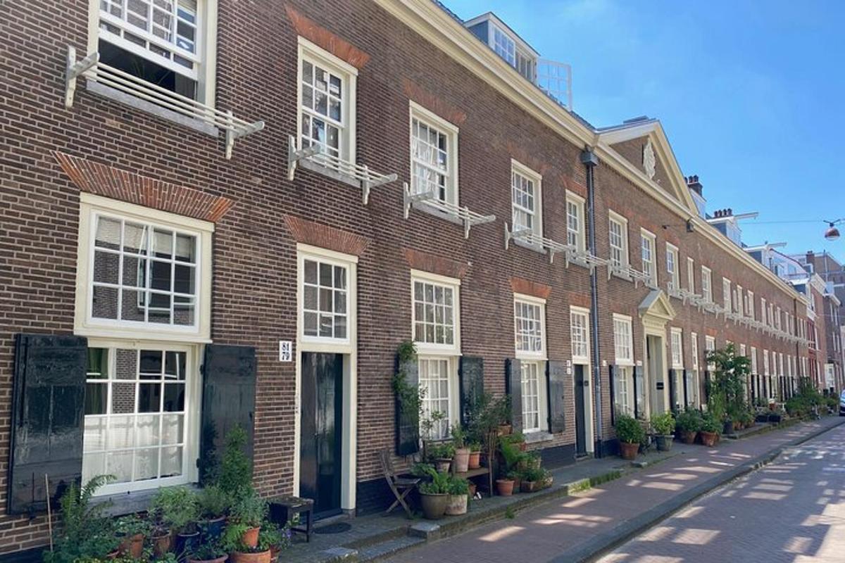 a red brick building with white windows and potted plants