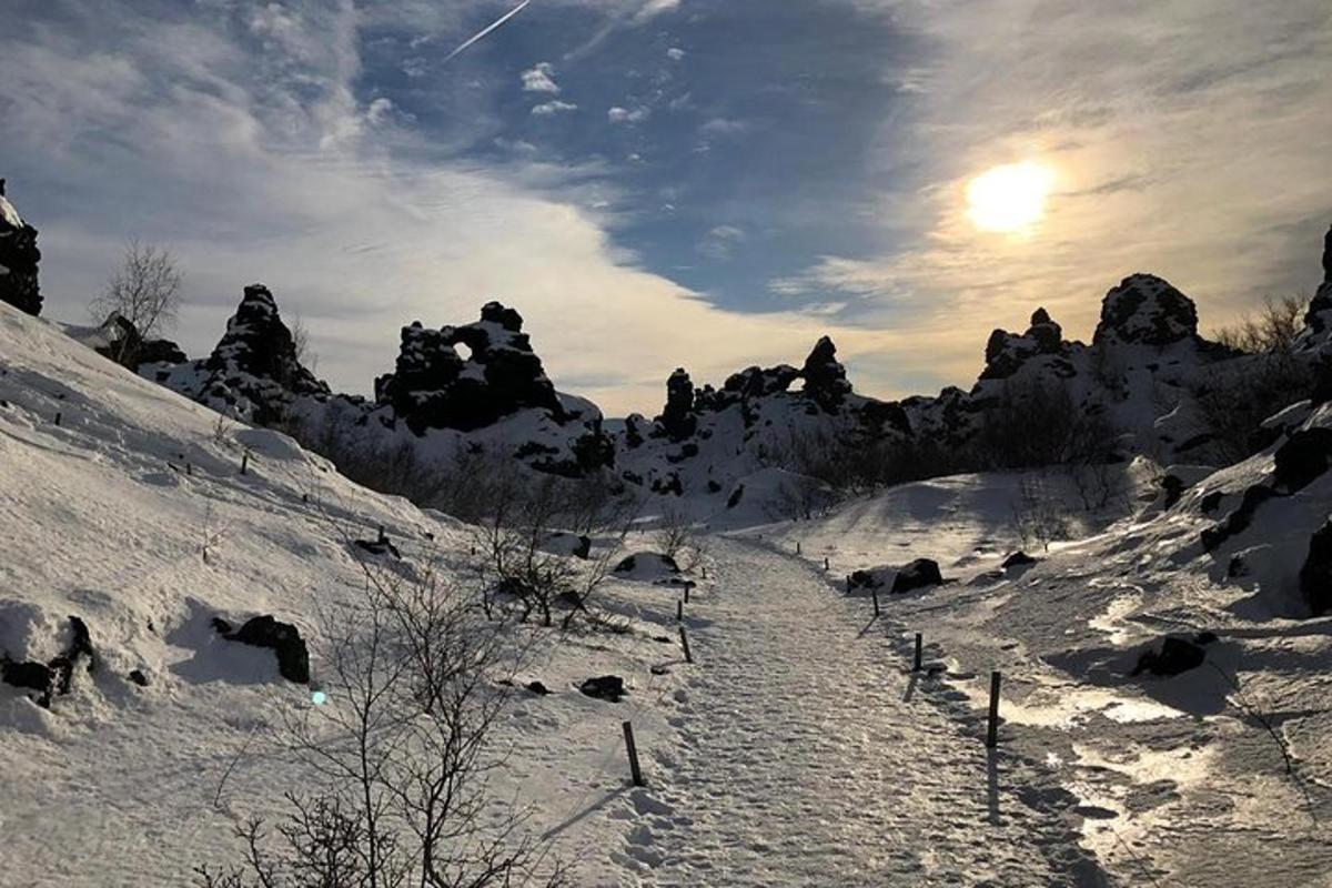 uma montanha coberta de neve com o sol no céu