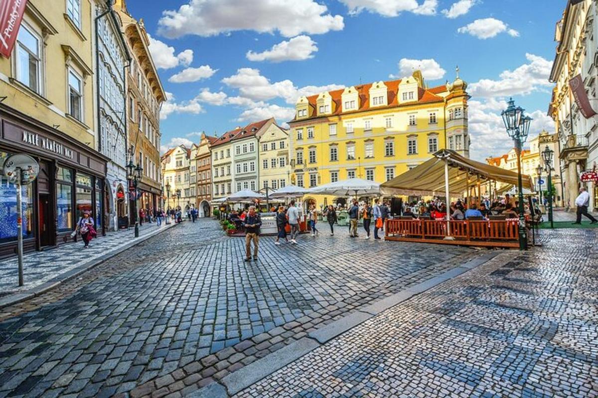 skupina lidí jdoucích po dlážděné ulici