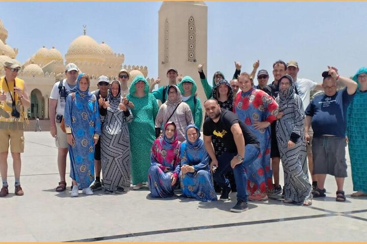 eine Gruppe von Menschen posiert für ein Foto vor einer Moschee