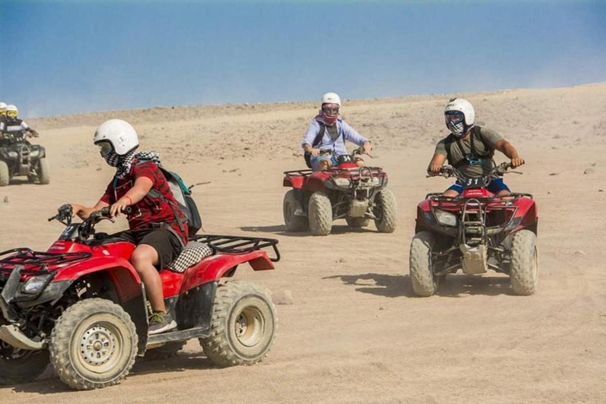 sekumpulan orang menunggang atv di padang pasir