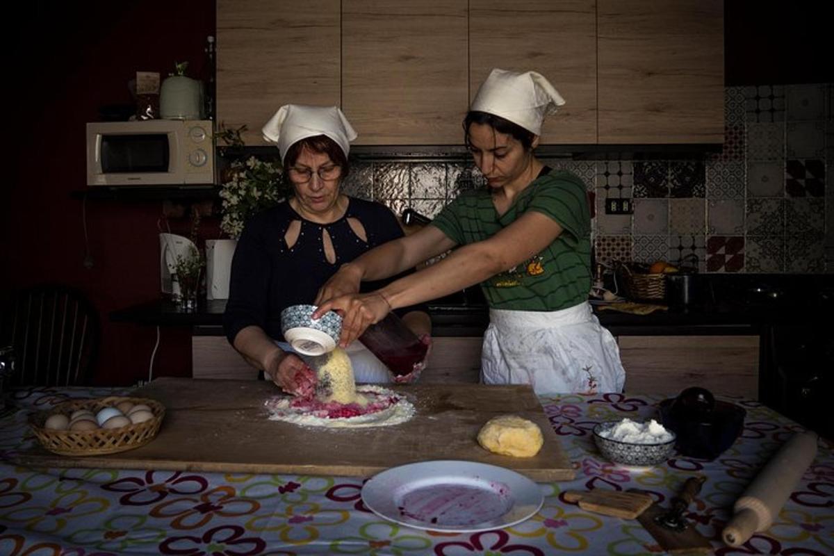 two women in a kitchen preparing food on a counter