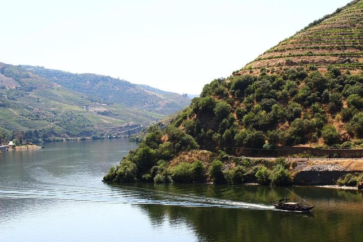 un barco que viaja por un río junto a una colina