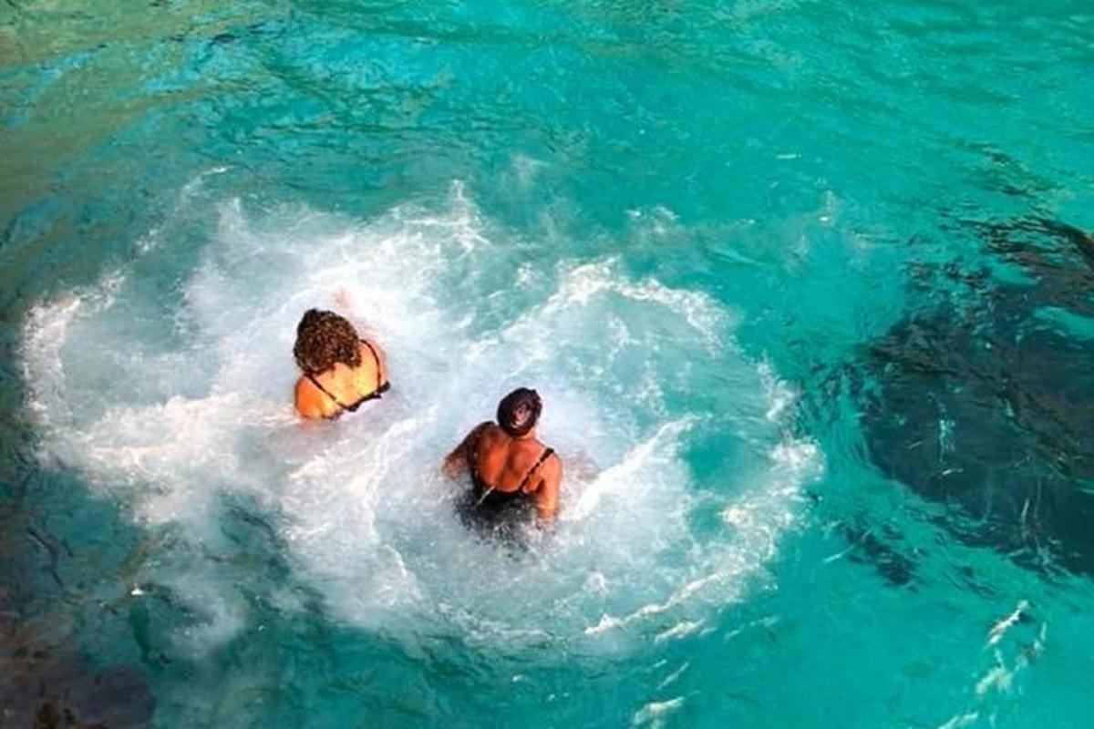 dos personas nadando en una piscina de agua