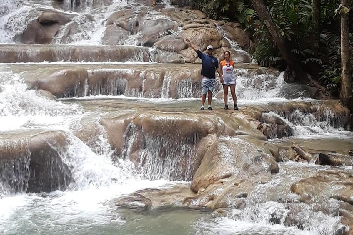 un uomo e una donna in piedi davanti a una cascata