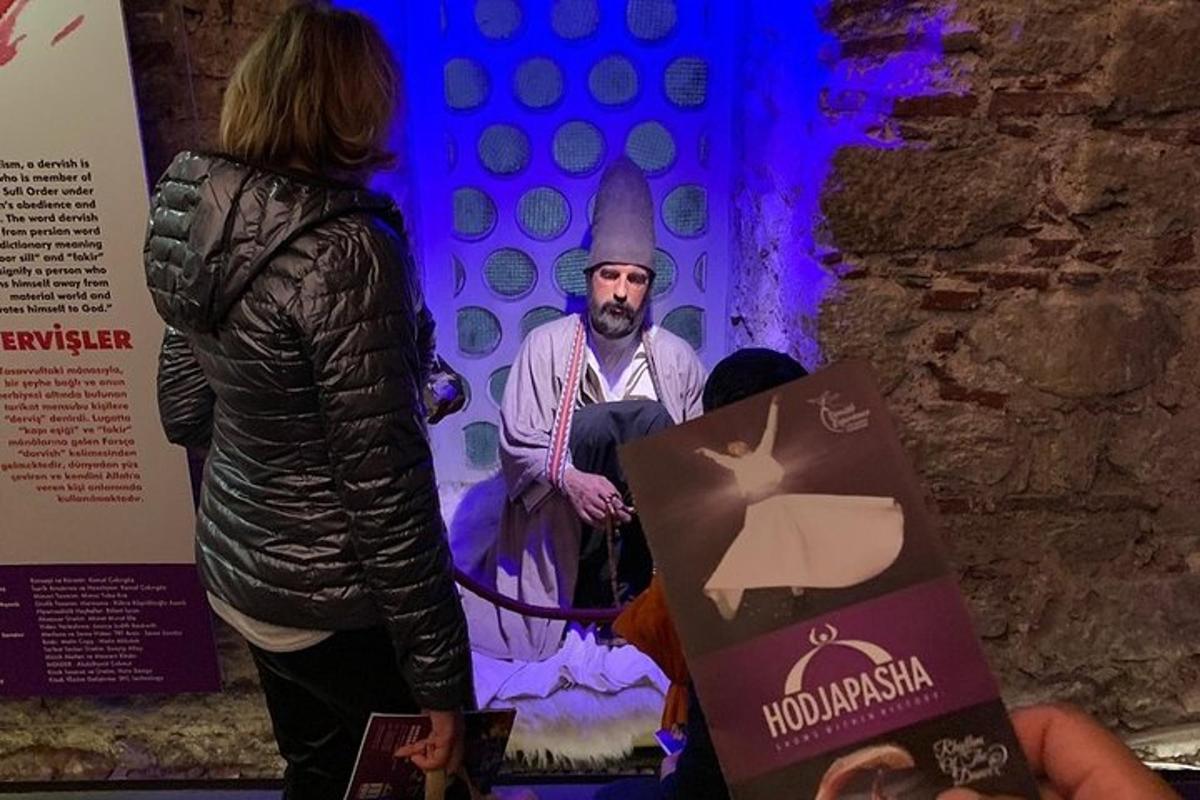 egy nő áll egy férfi szobra mellett