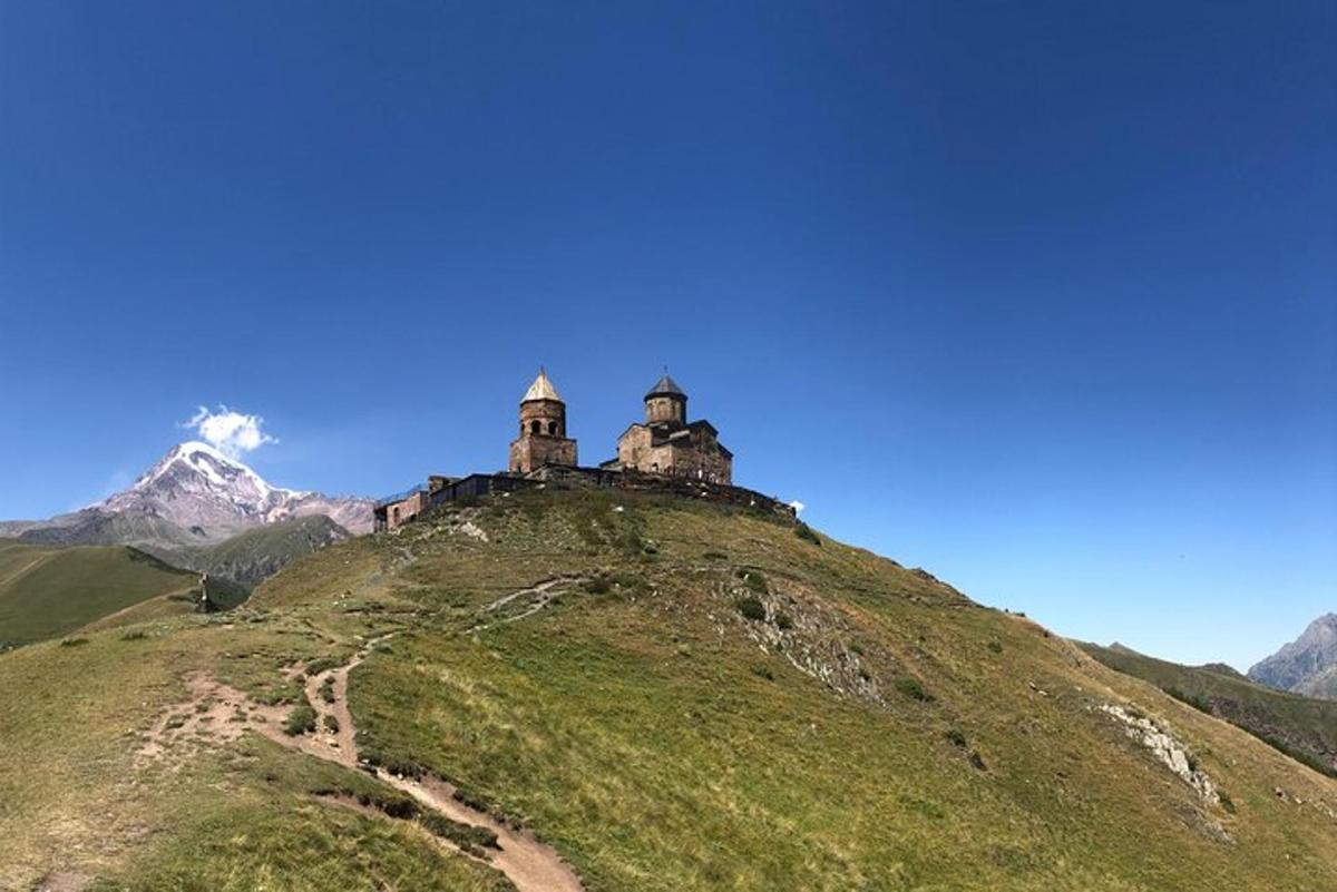 un castello in cima a una collina con una montagna