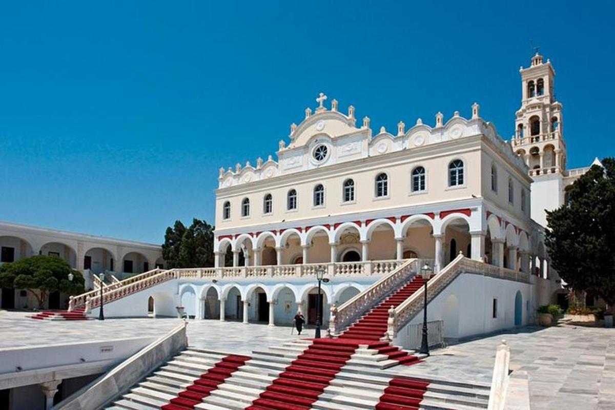 un gran edifici blanc amb escales vermelles al davant