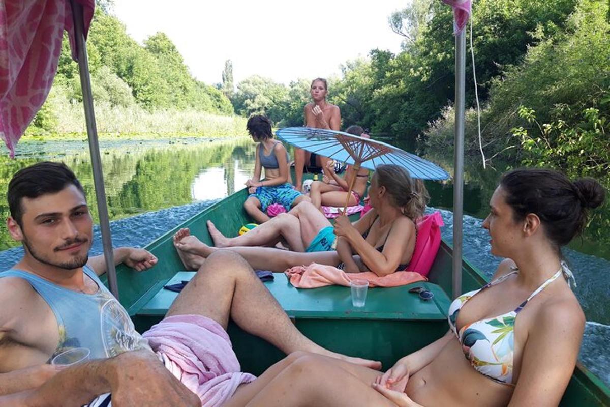 grupė žmonių, sėdinčių valtyje upėje