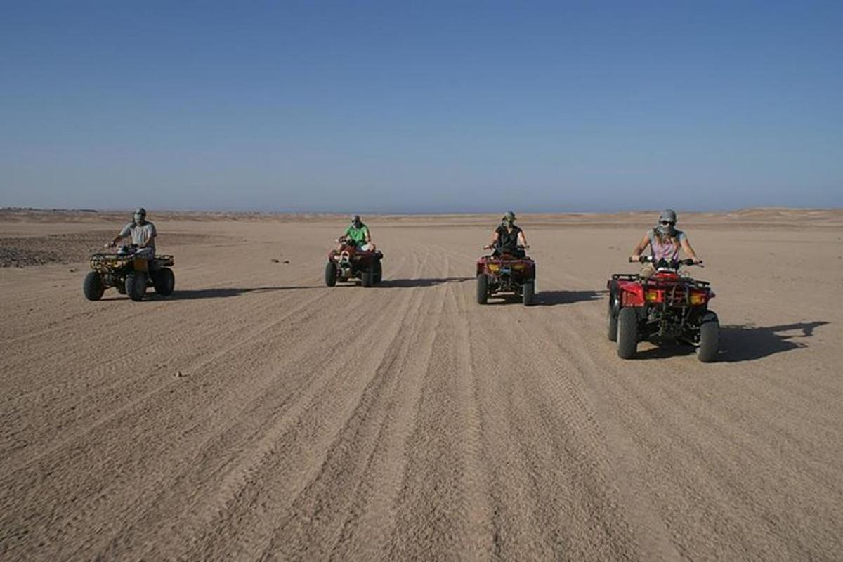 Un grupo de personas viajando en vehículos todo terreno en el desierto.