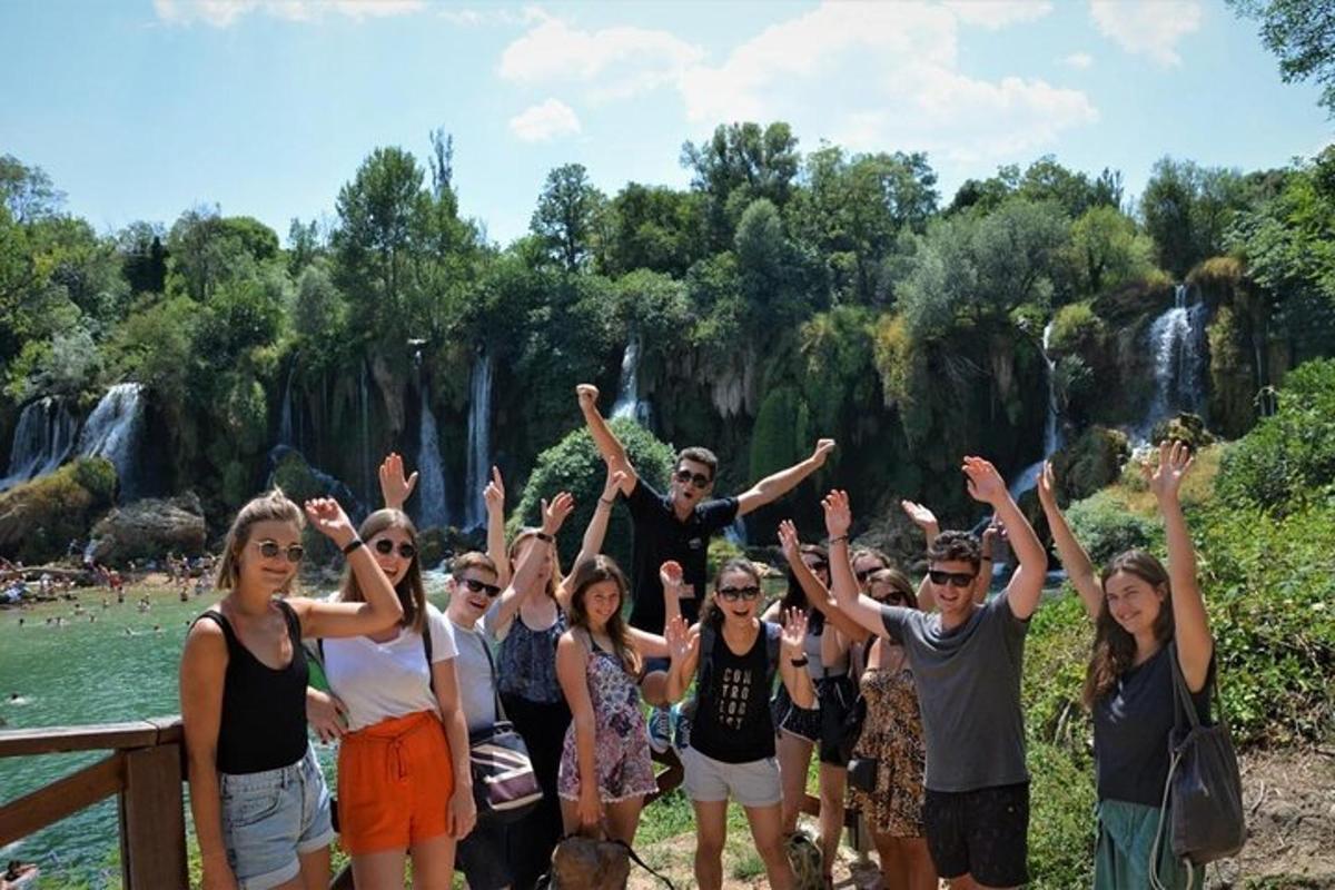 egy csoport ember áll egy vízesés előtt