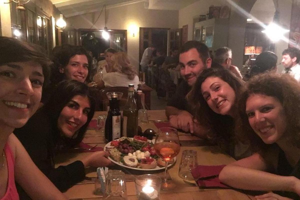 un gruppo di persone sedute a un tavolo con un piatto di cibo