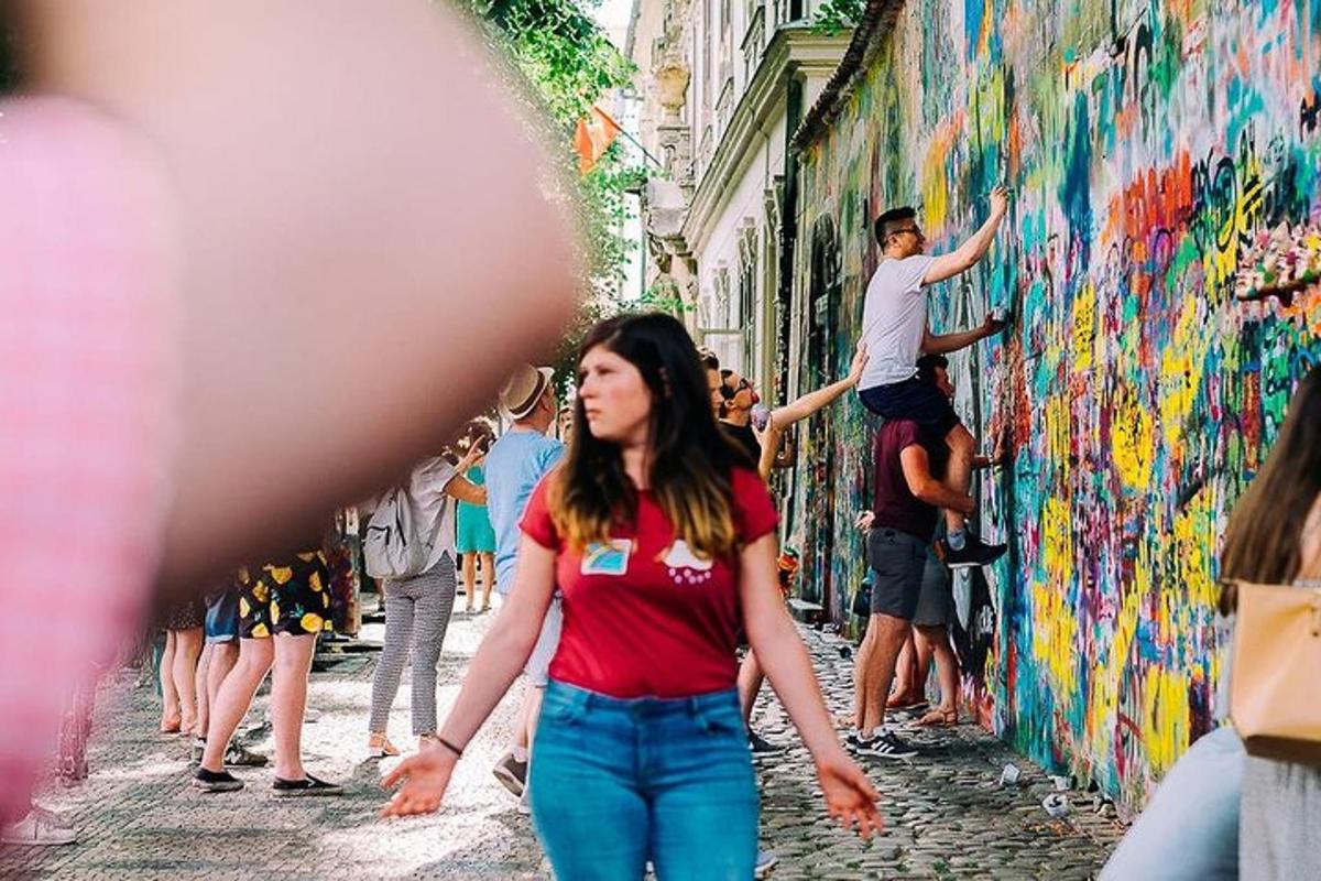 uma mulher caminhando pela rua em frente a um muro