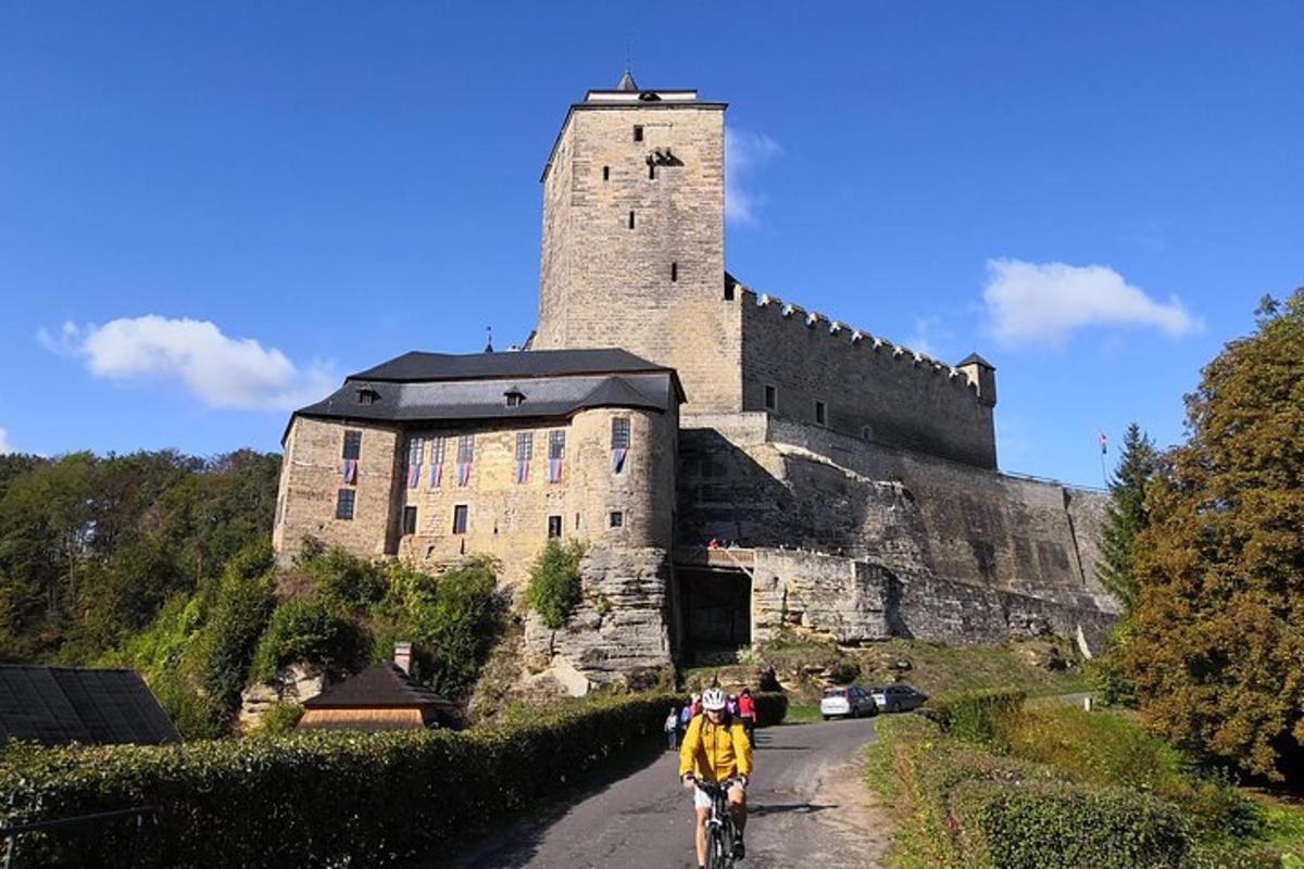 a man riding a bike down a road in front of a castle
