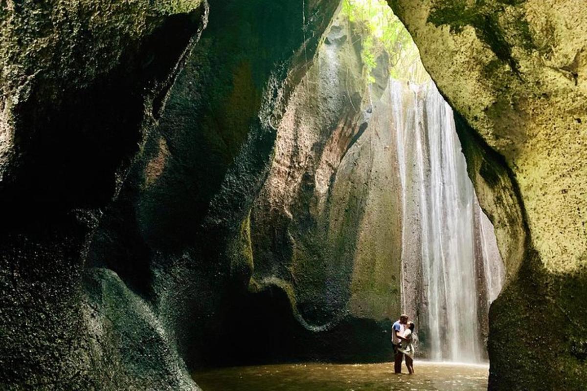 ein Mann steht vor einem Wasserfall
