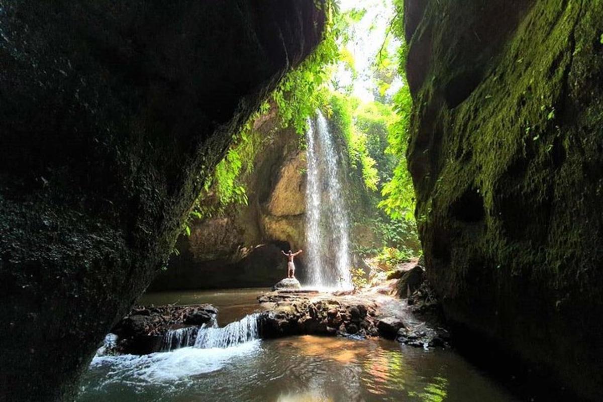 una persona in piedi davanti a una cascata