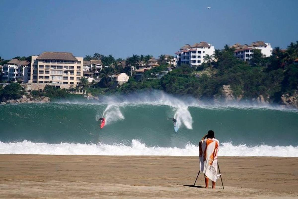 a man walking on the beach with a surfboard