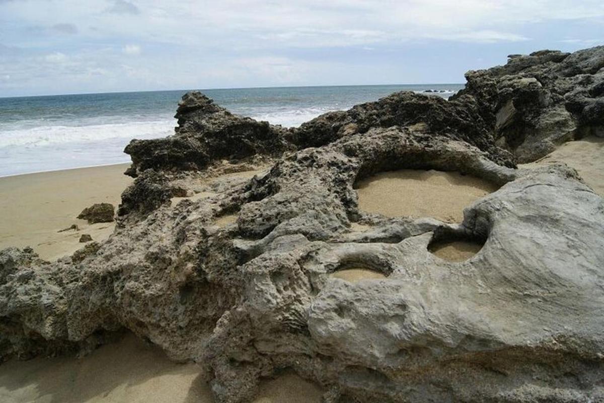 a rock formation on a beach with the ocean