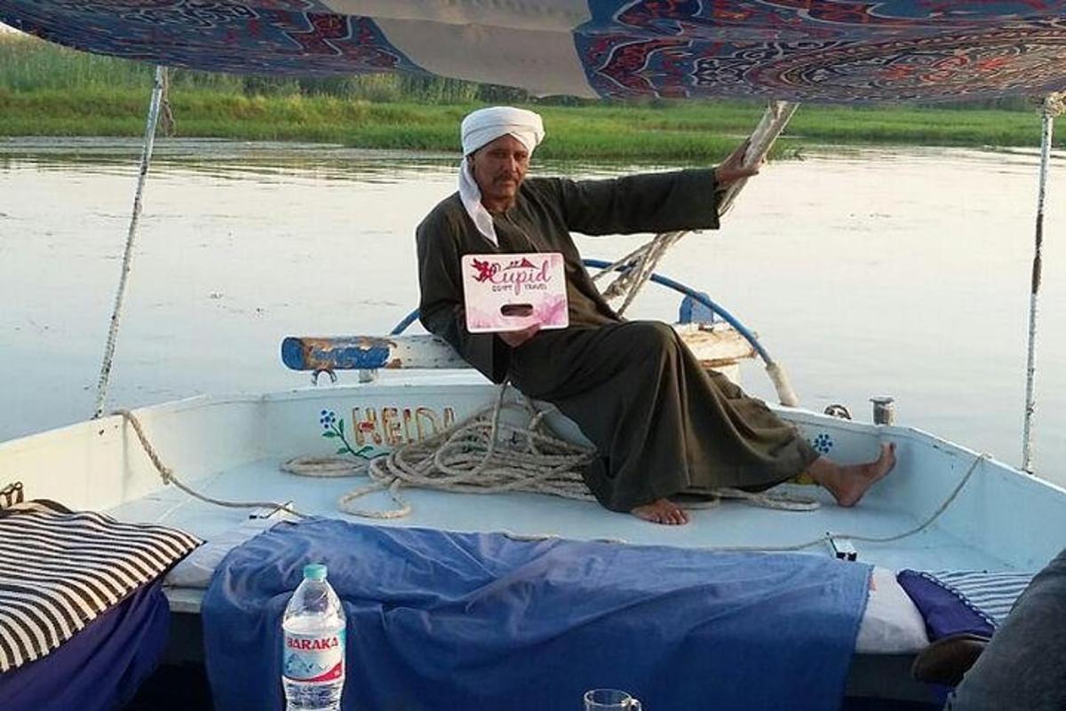 Un hombre sentado en un barco sosteniendo un cartel