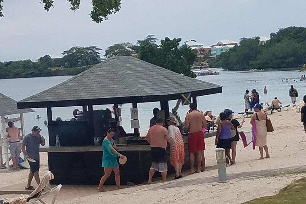 en gruppe mennesker står omkring en bar på stranden
