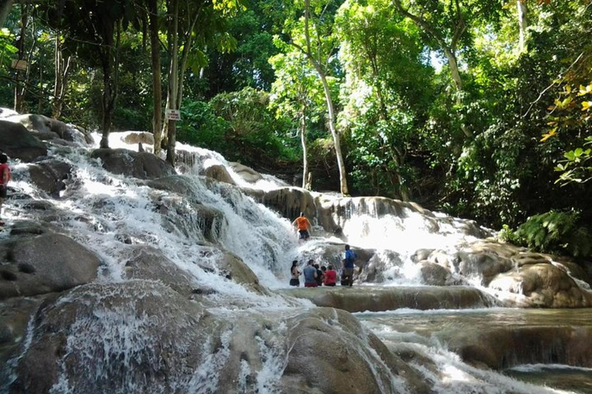 sekumpulan orang berdiri di hadapan air terjun