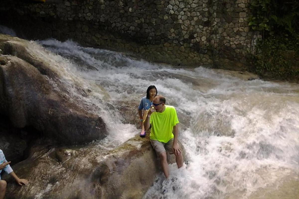 Un hombre y una mujer de pie sobre rocas en un río