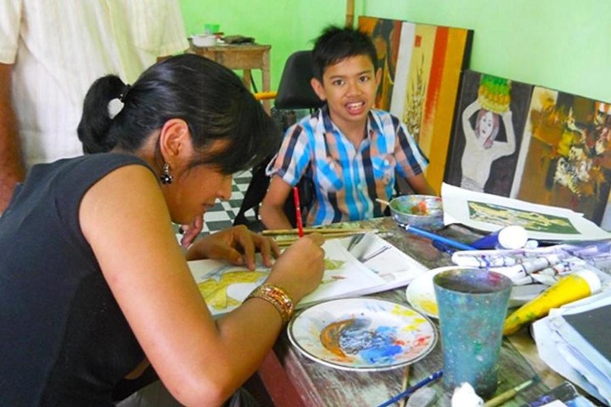 Una mujer dibujando la imagen de un niño en una mesa.