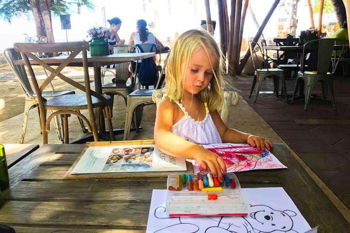 Una niña está cortando un pastel de cumpleaños
