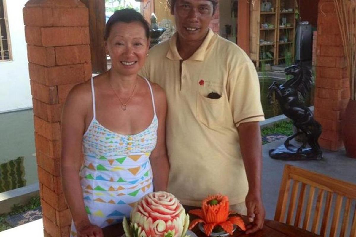 un uomo e una donna in piedi accanto a un tavolo con una torta