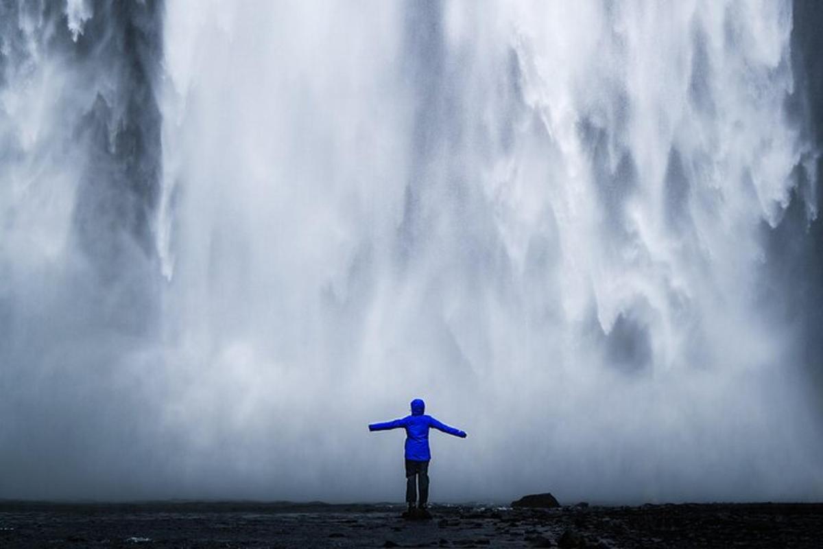 una persona in piedi davanti a una cascata