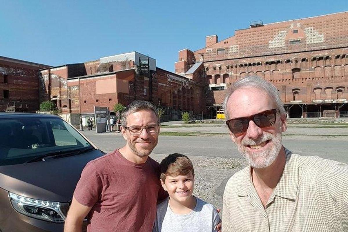 dwóch mężczyzn i dziecko stoją obok samochodu