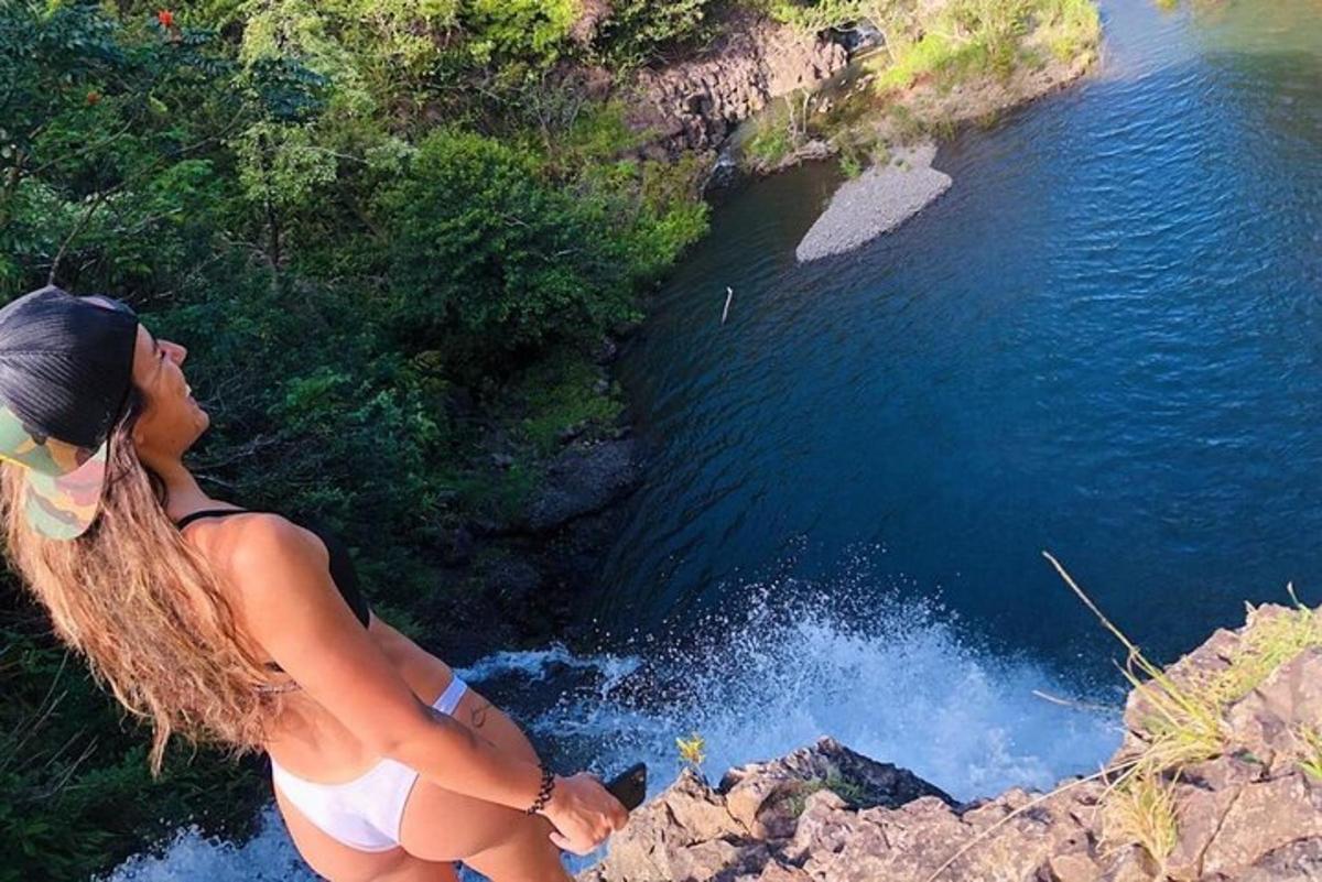 žena stojící na útesu a dívající se na řeku