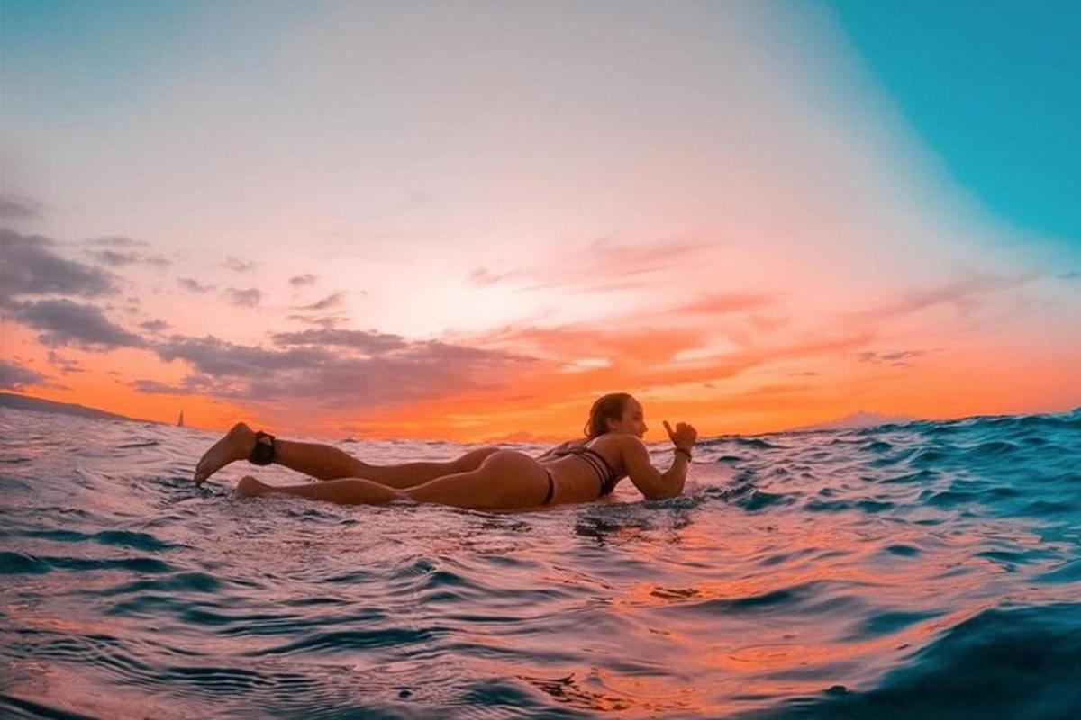 žena ležící na surfovém prkně v oceánu