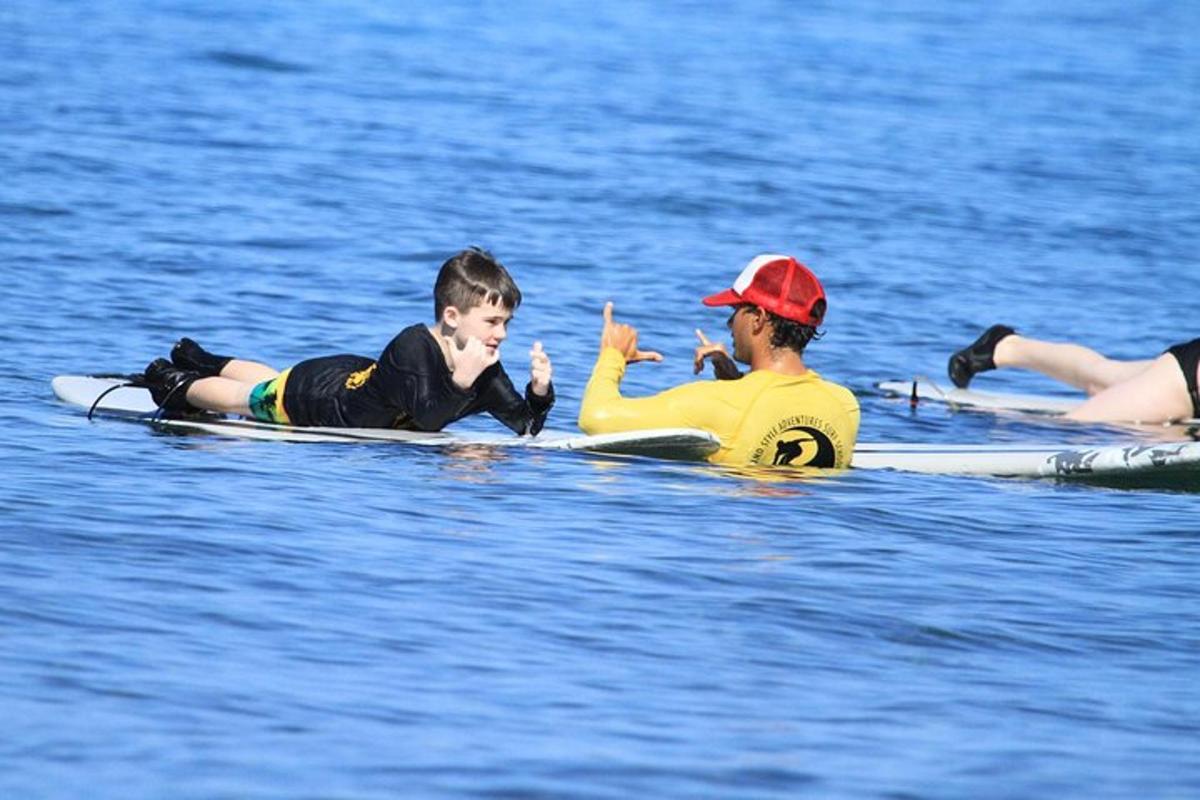 en mann og en gutt på surfebrett i vannet