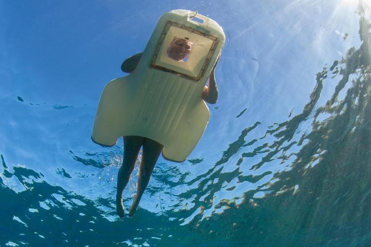 a person swimming in the water with a cell phone