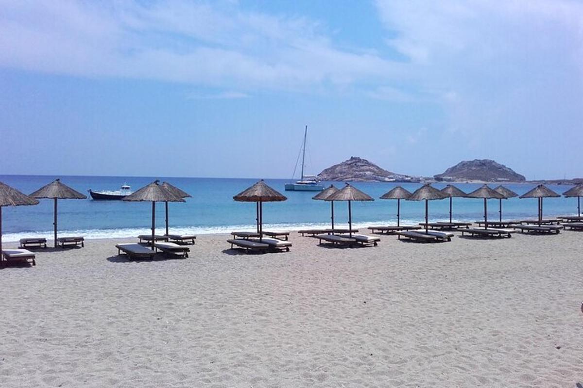 una spiaggia con molte sedie e ombrelloni sulla sabbia
