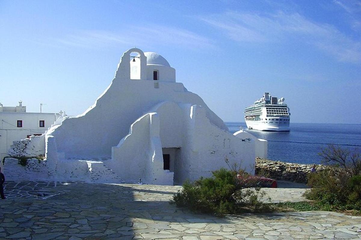 un edificio bianco con una nave da crociera nell'oceano