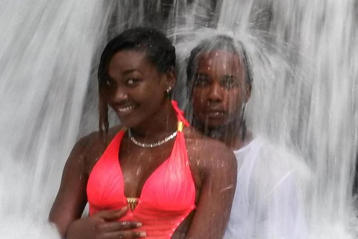 un uomo e una donna in piedi davanti a una cascata